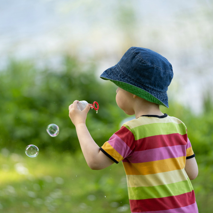 Litet pojke blåsar bubblar